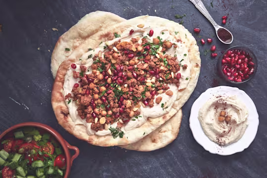 Healthy flatbread layered with Quorn Mince dressed with pomegranate seeds and chopped parsley with a side of hummus