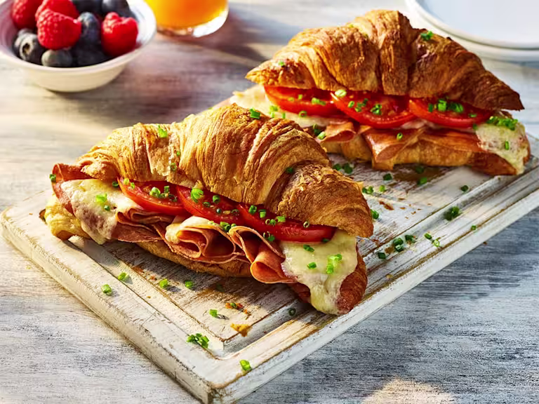 Two Air Fryer Vegetarian Croissants with the filling visible including Quorn Ham, sliced tomatoes and melted cheese.