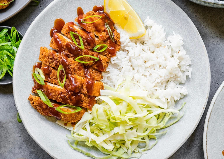 A plate of Quorn Vegetarian Chicken Katsu curry featuring Quorn Homestyle ChiQin Cutlets slices and a side of rice. 