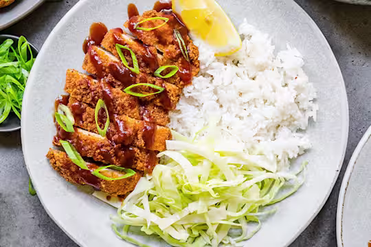 A plate of Quorn Vegetarian Chicken Katsu curry featuring Quorn Homestyle ChiQin Cutlets slices and a side of rice.