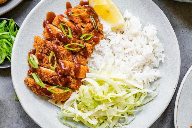 A plate of Quorn Vegetarian Chicken Katsu curry featuring Quorn Homestyle ChiQin Cutlets slices and a side of rice. 