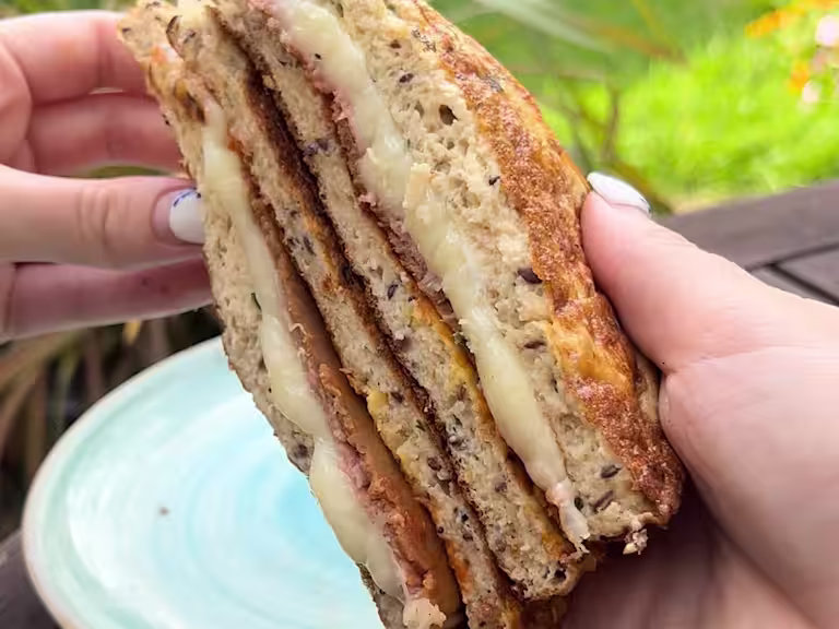 Somebody holding a cheese toastie with Quorn Roast Beef and Vegetarian Ham Slices