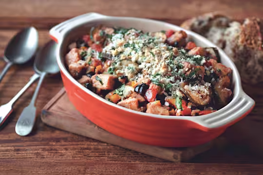 A baking dish of ratatouille made with Quorn Pieces and topped with cheese and breadcrumbs.