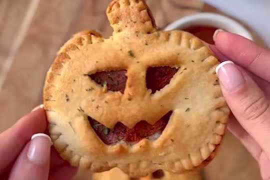 A single Air Fryer Pumpkin Pizza Pie, with a face cut out to show the Quorn Vegan Pepperoni.