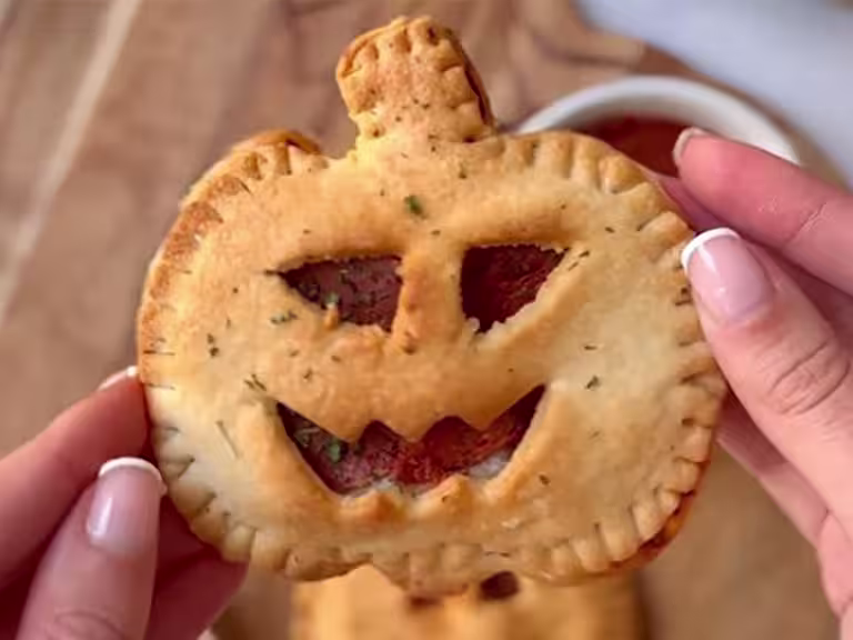 A single Air Fryer Pumpkin Pizza Pie, with a face cut out to show the Quorn Vegan Pepperoni.
