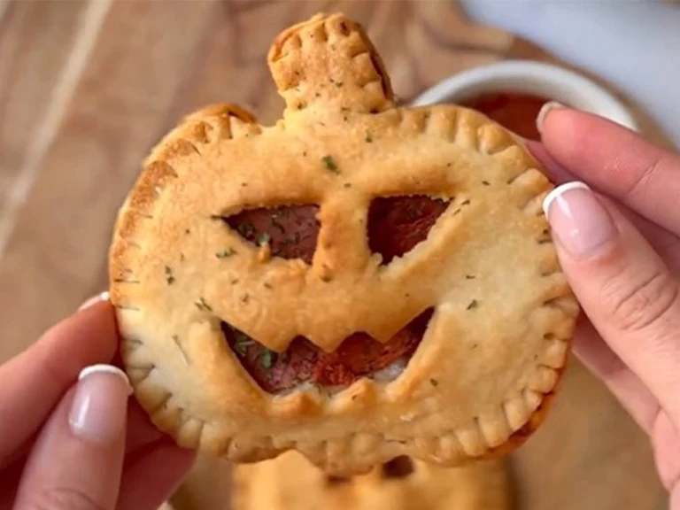 A single Air Fryer Pumpkin Pizza Pie, with a face cut out to show the Quorn Vegan Pepperoni.