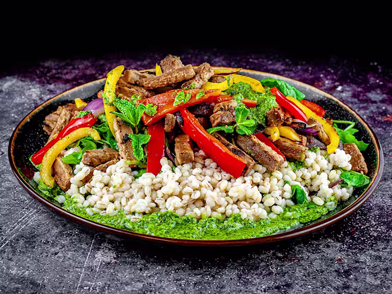 Pearl bailey, pepper and Quorn steak strip salad with salsa served on a rounded dish.