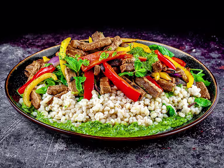 Pearl bailey, pepper and Quorn steak strip salad with salsa served on a rounded dish.
