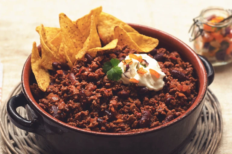 Vegetarian Quorn Chilli con Carne served in a casserole dish topped with nachos