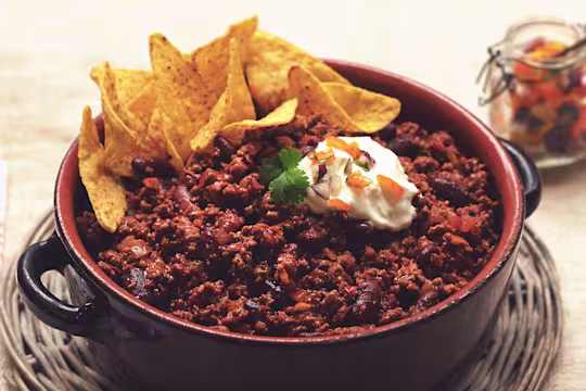 Vegetarian Quorn Chilli con Carne served in a casserole dish topped with nachos