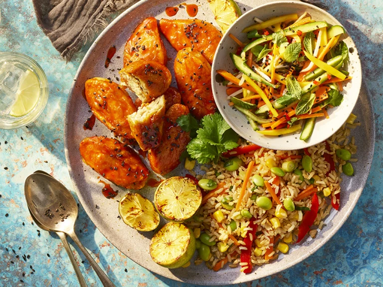 Quorn sriracha wings served alongside fried rice and a side of vegetables.