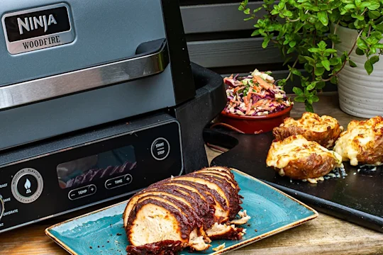 BBQ Quorn Roast next to a plate of loaded potato skins and homemade coleslaw.