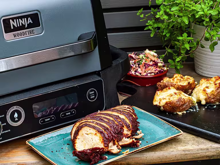 BBQ Quorn Roast next to a plate of loaded potato skins and homemade coleslaw.