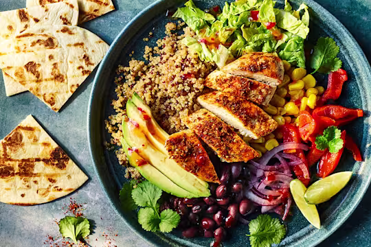Naked burrito bowl with Quorn Meatless ChiQin Fillets served in a bowl with pitta bread on the side.