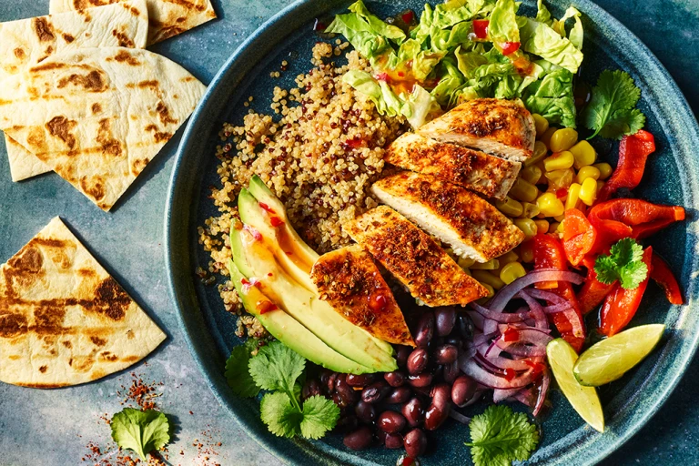 Naked burrito bowl with Quorn Meatless ChiQin Fillets served in a bowl with pitta bread on the side.