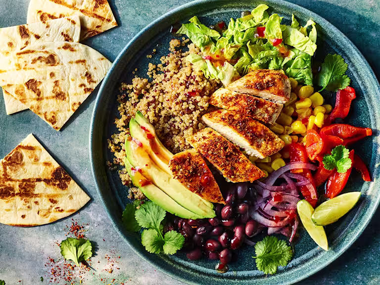 Naked burrito bowl with Quorn Meatless ChiQin Fillets served in a bowl with pitta bread on the side.