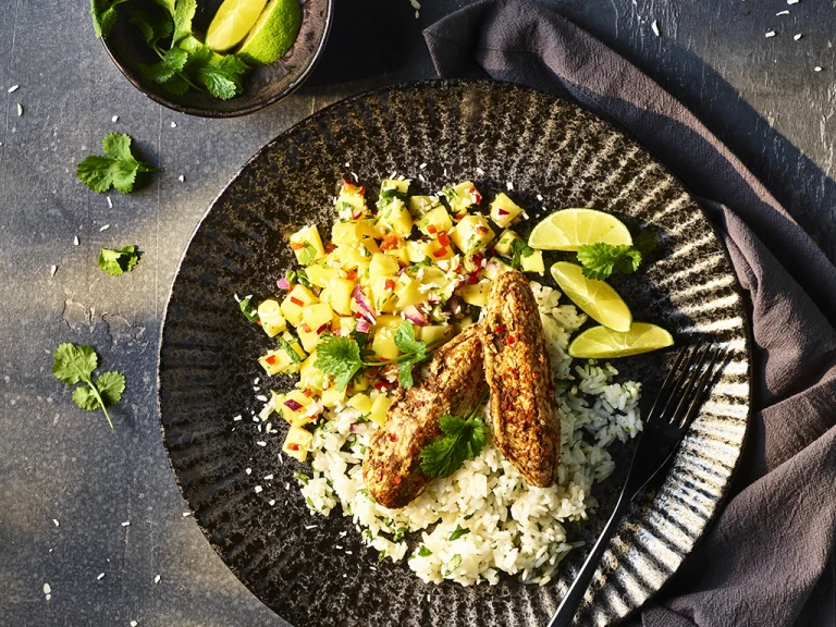Quorn Jerk Mini Fillets with Sticky Coconut Rice served in a bowl with avocado on the side.