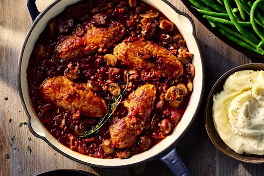 Vegetarian Co au Vin made using Quorn Fillets served in a large dish with a side dish of mashed potatoes.