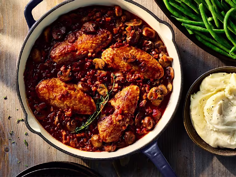Vegetarian Co au Vin made using Quorn Fillets served in a large dish with a side dish of mashed potatoes.