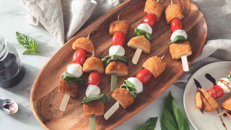 Quorn Caprese Skewers served on a wooden dish.