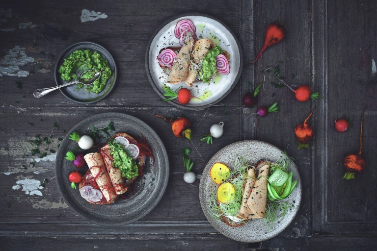 Quorn Spinach and Red Pepper Slices served on sliced bread with beetroot, radish and cress on a table scattered with radishes