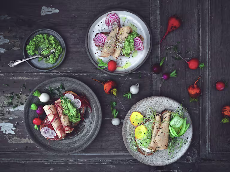 Quorn Spinach and Red Pepper Slices served on sliced bread with beetroot, radish and cress on a table scattered with radishes