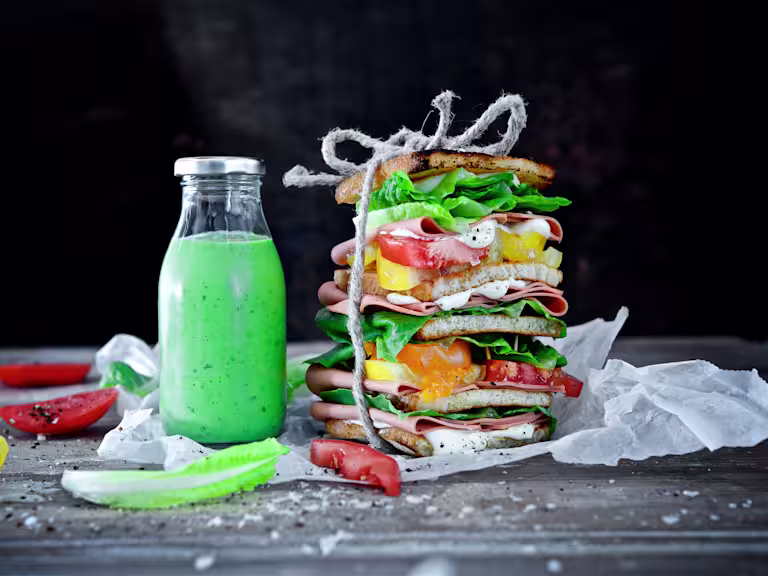 Spenat- och avokadosallad toppad med Quorn minifiléer på blå tallrik.