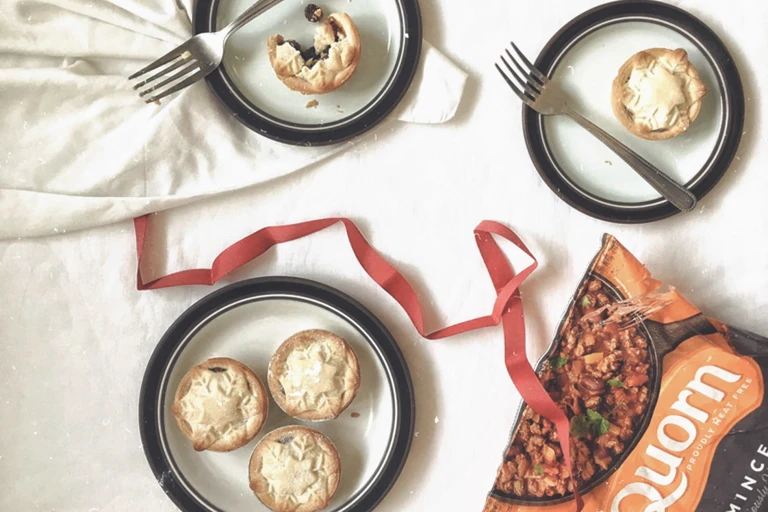 Mince pie recipe made with Quorn Mince served on white plates with black rim, dessert forks and a strand of ribbon on the table