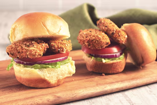 Veggie burger recipe made with Quorn Vegan Crunchy Nuggets and salad served on a wooden tray