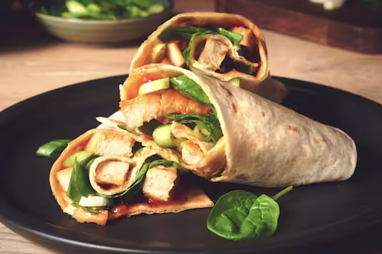 Easy lunch idea of sweet chilli wraps made with vegetarian Quorn Roast Mini Fillets served on a black plate