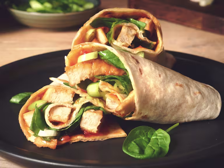 Easy lunch idea of sweet chilli wraps made with vegetarian Quorn Roast Mini Fillets served on a black plate