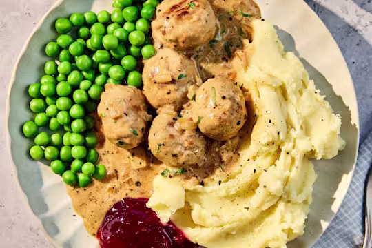 Plate of meat-free Quorn Swedish Style Balls made with Quorn Balls, served with mashed potatoes, peas and creamy gravy.