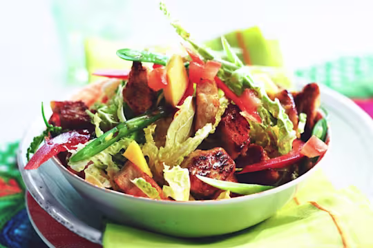 A bowl of Thai salad with marinated Quorn pieces, beans, peppers, chili and mango.