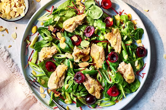 Vegetarian Coronation Chicken salad sprinkled with almond slices next to a pale pink napkin.