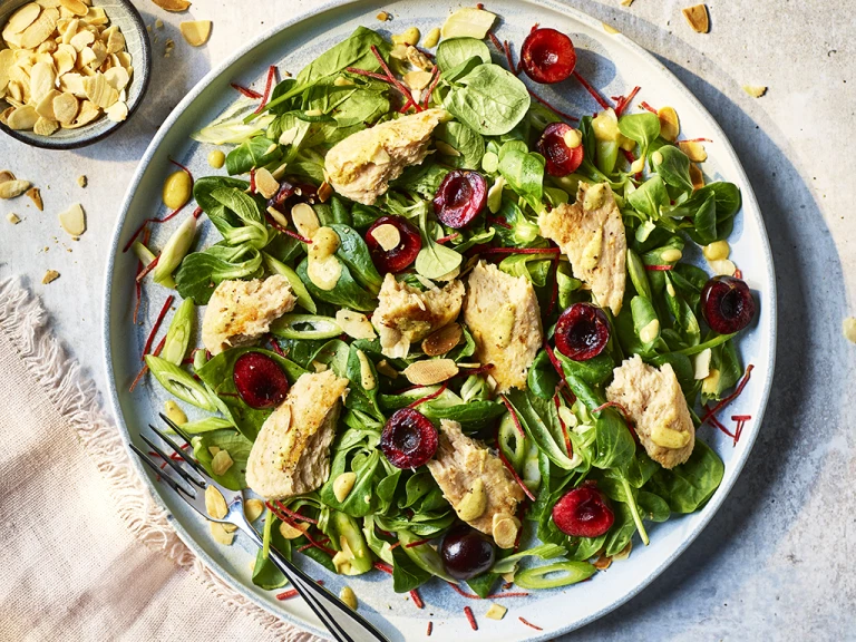 Vegetarian Coronation Chicken salad sprinkled with almond slices next to a pale pink napkin.  