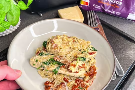 En gratängform med krämig vegetarisk risoni, toppad med Quorn Filéer, soltorkade tomater och färsk spenat.