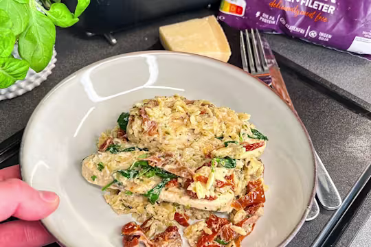 En gratängform med krämig vegetarisk risoni, toppad med Quorn Filéer, soltorkade tomater och färsk spenat.