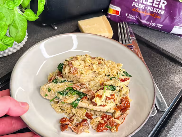 En gratängform med krämig vegetarisk risoni, toppad med Quorn Filéer, soltorkade tomater och färsk spenat.