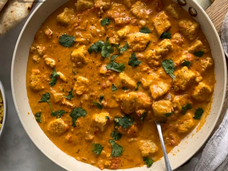 Vegetarian Quorn pieces curry in a dish garnished with coriander and served with a spoon.