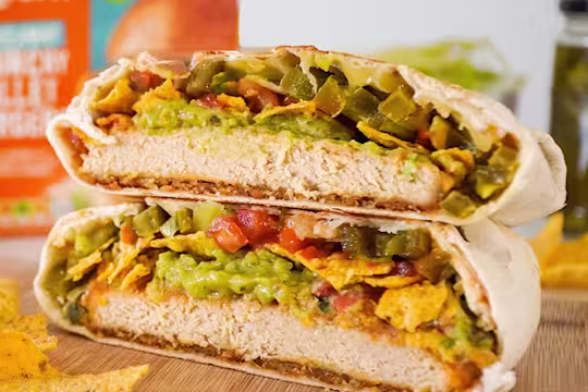 The Quorn Crunchy Fillet Burger Crunchwrap sliced served on a board with the Quorn Fillet Burger in the back