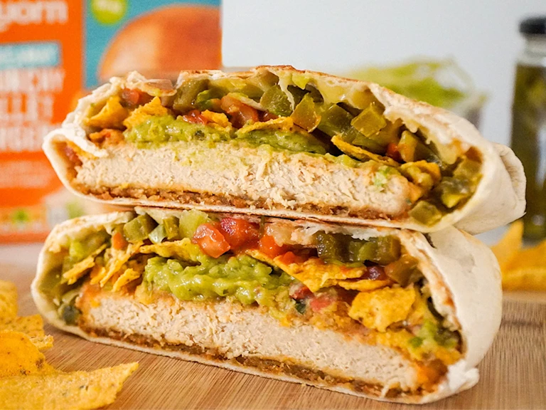 The Quorn Crunchy Fillet Burger Crunchwrap sliced served on a board with the Quorn Fillet Burger in the back