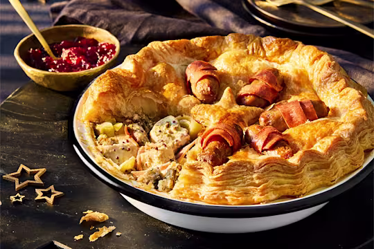 A Vegetarian Chicken & Stuffing Festive Pie, made with Quorn Pieces, on a black background.
