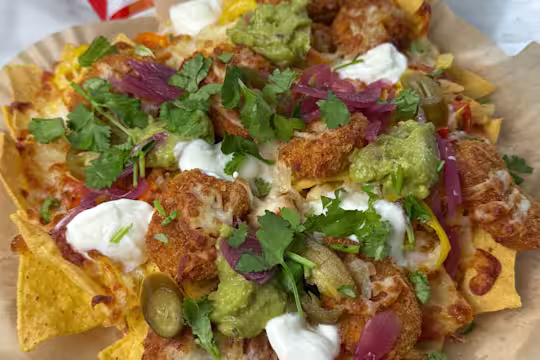Quorn Cheesy Nacho Nuggs on a layer of tortilla chips with Greek yoghurt, pickled red onion, jalapenos and melted cheese.