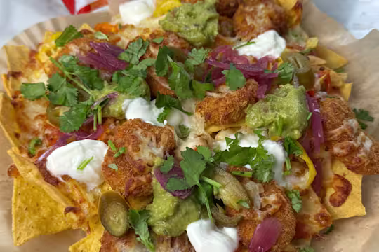 Quorn Cheesy Nacho Nuggs on a layer of tortilla chips with Greek yoghurt, pickled red onion, jalapenos and melted cheese.