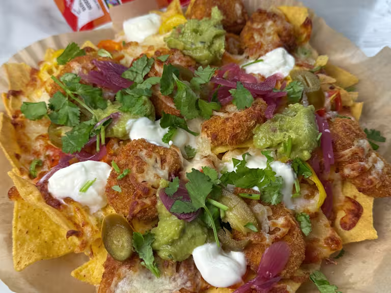Quorn Cheesy Nacho Nuggs on a layer of tortilla chips with Greek yoghurt, pickled red onion, jalapenos and melted cheese.