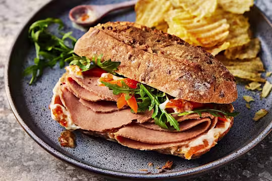 Vegetarian Ham Sandwich With Marmalade Crème Fraiche featuring Quorn Vegetarian Ham Style Slices and served with a slide of crisps.