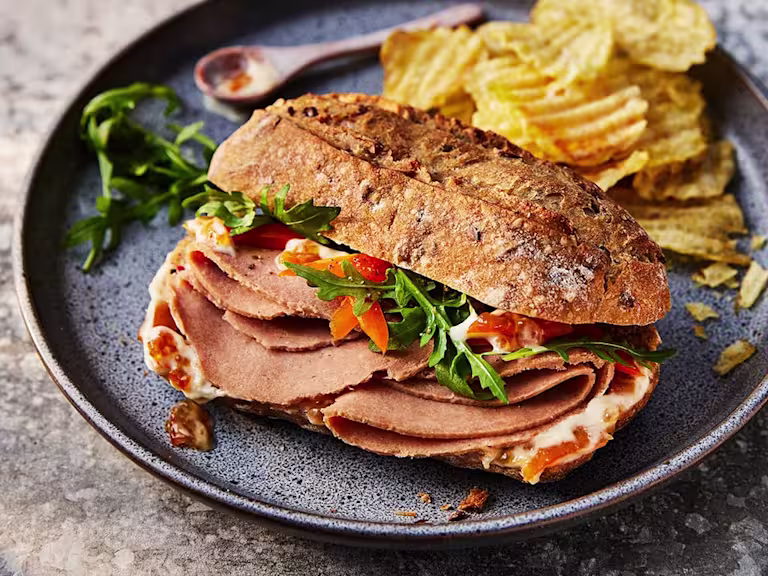 Vegetarian Ham Sandwich With Marmalade Crème Fraiche featuring Quorn Vegetarian Ham Style Slices and served with a slide of crisps.