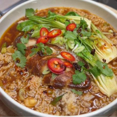 Quorn Fillets in a vegetable broth with rice, pak choi, spring onions, coriander and chilli served in a bowl.