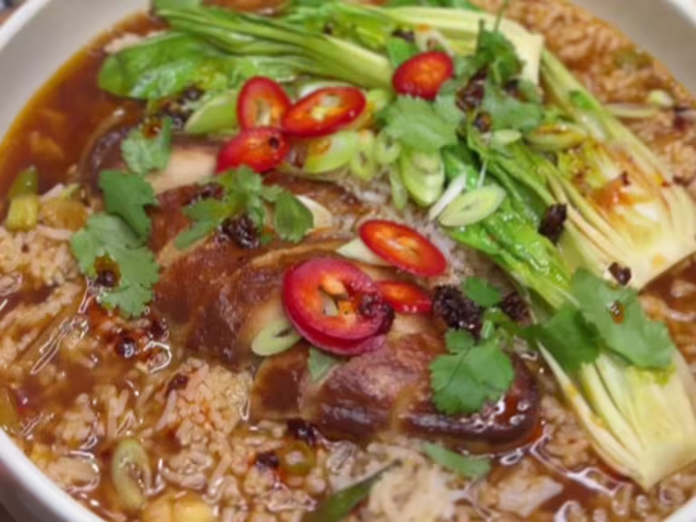 Quorn Fillets in a vegetable broth with rice, pak choi, spring onions, coriander and chilli served in a bowl.