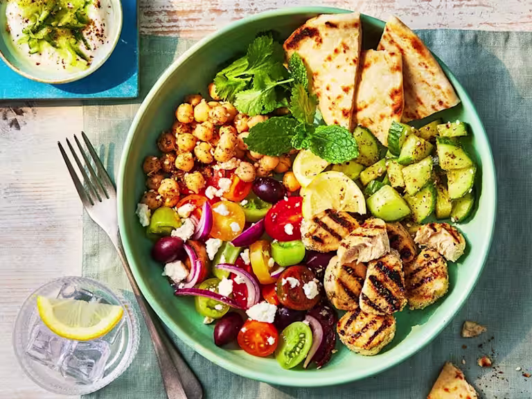 A salad consisting of Quorn chicken pieces, tomatoes and chickpeas alongside pita bread